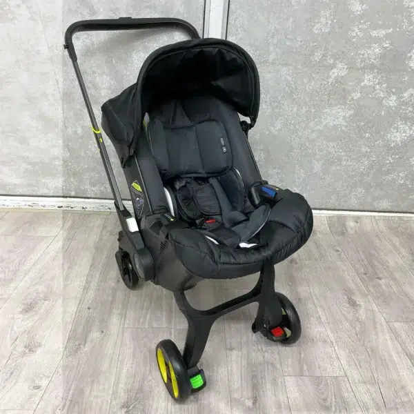 A sleek 4-in-1 baby stroller in black, featuring a secure car seat, carry cot, and adjustable handle. Designed for comfort, safety, and easy mobility.
