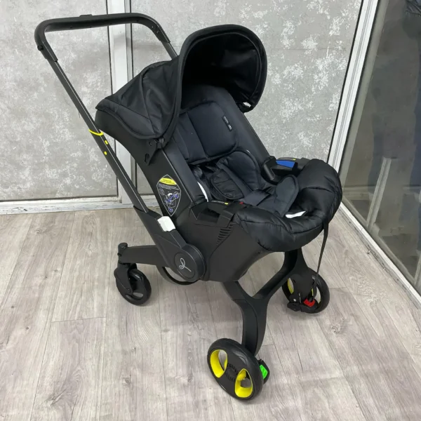 A sleek 4-in-1 baby stroller in black, featuring a secure car seat, carry cot, and adjustable handle. Designed for comfort, safety, and easy mobility.