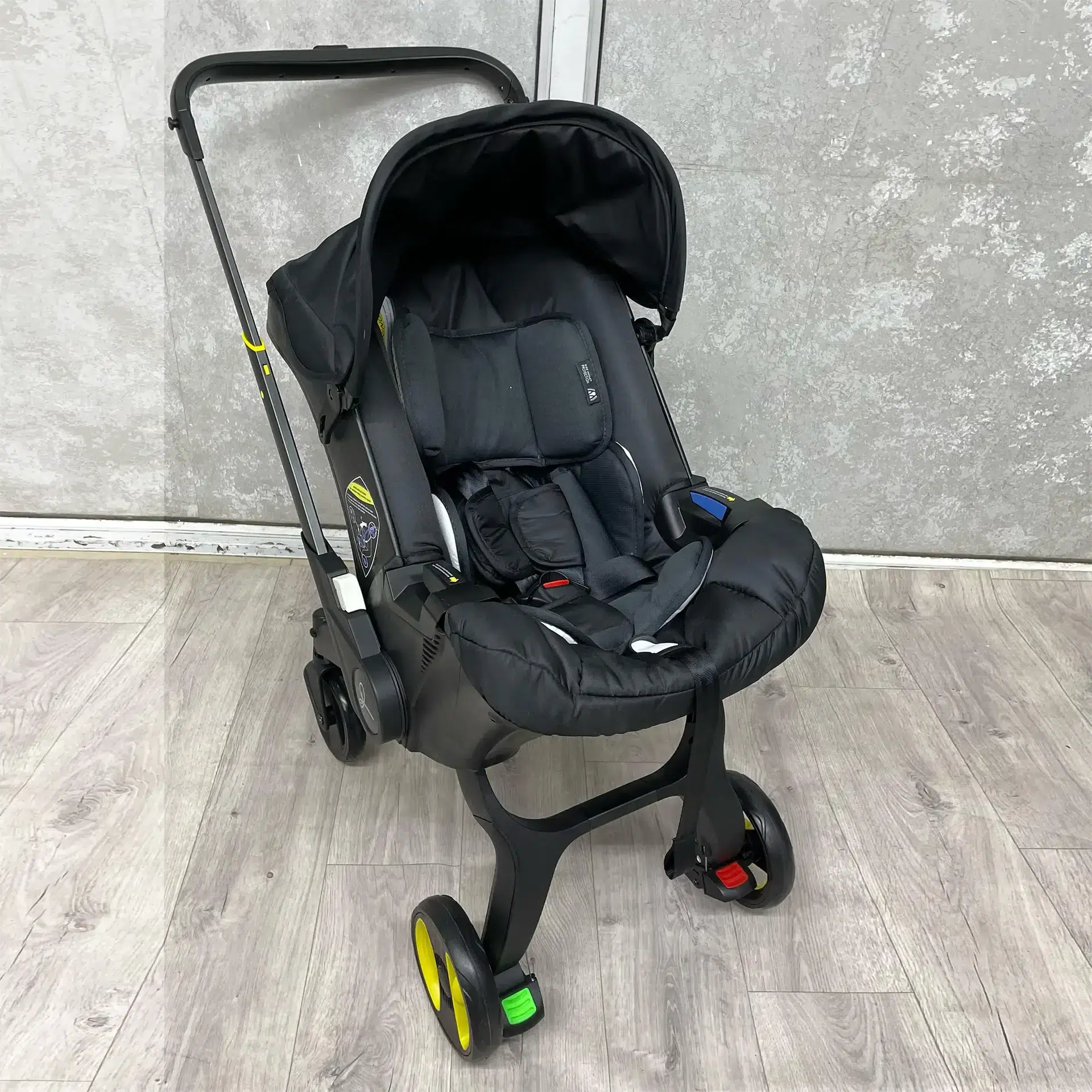 A sleek 4-in-1 baby stroller in black, featuring a secure car seat, carry cot, and adjustable handle. Designed for comfort, safety, and easy mobility.