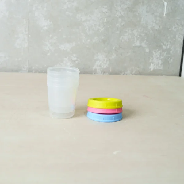 Packaged set of Momeasy Baby Food Storage Containers (3 pieces, 180ml each), featuring vibrant lids in pink, blue, and yellow, with BPA-free and microwave-safe labels.