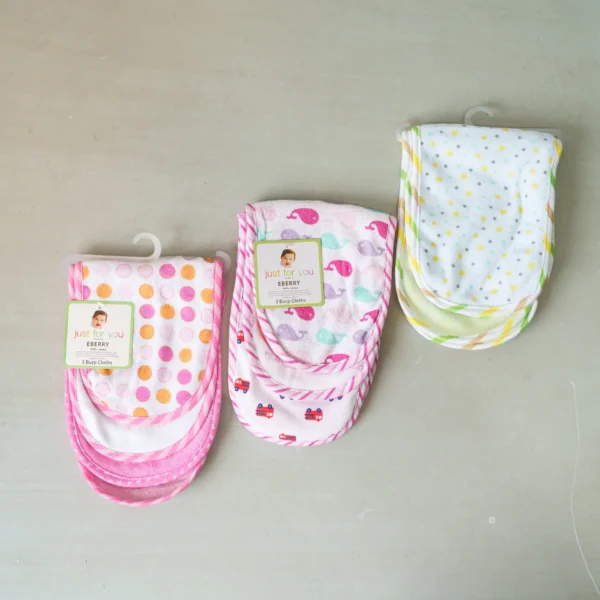 A set of colorful baby burp cloths from the "Just for You" brand, neatly packaged and displayed. Patterns include polka dots, whales, cars, and star prints.