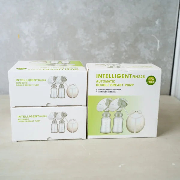 Boxes of the Intelligent RH228 Automatic Double Breast Pump displayed on a light surface. The packaging highlights BPA-free components and features such as a dual mode for stimulation and expression, along with a compact motor unit and two milk collection bottles with flanges, designed for comfortable and efficient milk pumping.