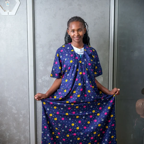 Woman modeling a navy blue nursing dera featuring a colorful floral print, highlighting the garment’s modest coverage and relaxed fit.