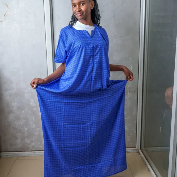 Woman wearing a blue nursing dera with subtle geometric print, holding the sides to show the loose fit and full-length design.