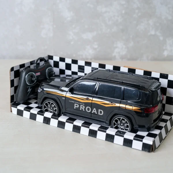 Remote control toy SUV car in black with “Land Cruiser PROAD” branding, displayed in a checkered packaging with the controller