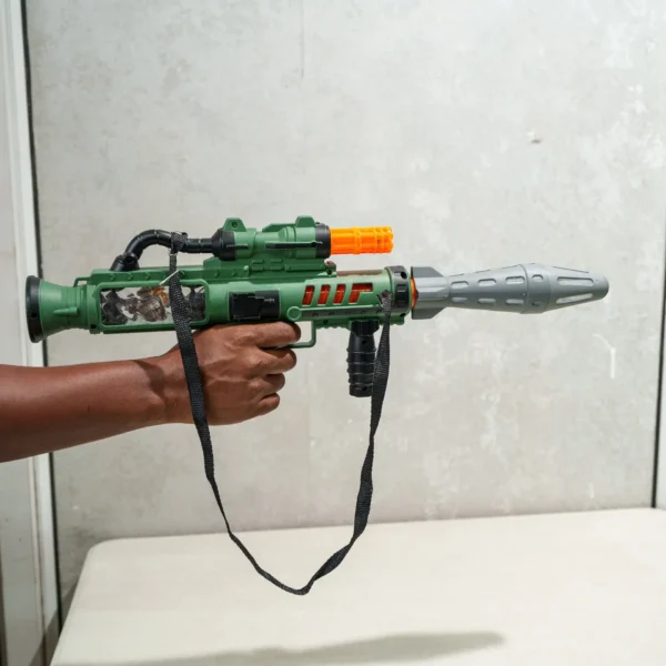 Child holding a green toy rocket launcher gun with scope, strap, and orange muzzle tip, designed for imaginative play and safe handling